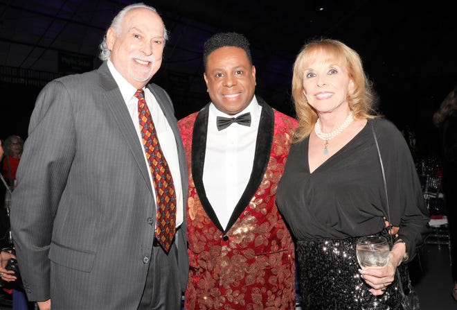 Jay Richmond (L) and Linda Steinberger (R) pose with  WBTT Founder and Artistic Director Nate Jacobs (C). The Westcoast Black Theatre Troupe’s 22nd Anniversary Gala was held on Saturday, December 4, 2021 at the Circus Arts Conservatory’s Sailor Circus Arena in Sarasota, Florida. The event titled “A Night at the Savoy” turned the arena into a replication of New York City’s famous Harlem public, no-discrimination ballroom, The Savoy, which was in operation from 1926 – 1958. WBTT uses funds for education, artist development and a mentoring program geared toward underserved young people.