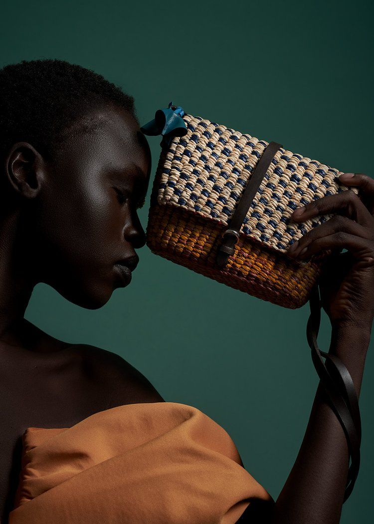 a beautiful model holding a straw bag