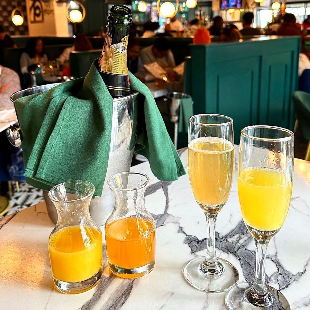 The mimosa service at Breakfast at Barney’s in Atlanta includes a bottle of champagne and carafes of orange juice to make your own cocktails