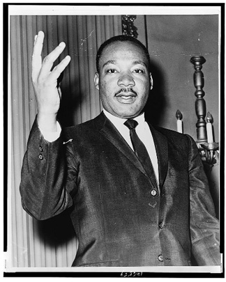 Half-length portrait of Dr. Martin Luther King, Jr., facing front with right arm lifted. Half-length portrait of Dr. Martin Luther King, Jr., facing front with right arm lifted.
