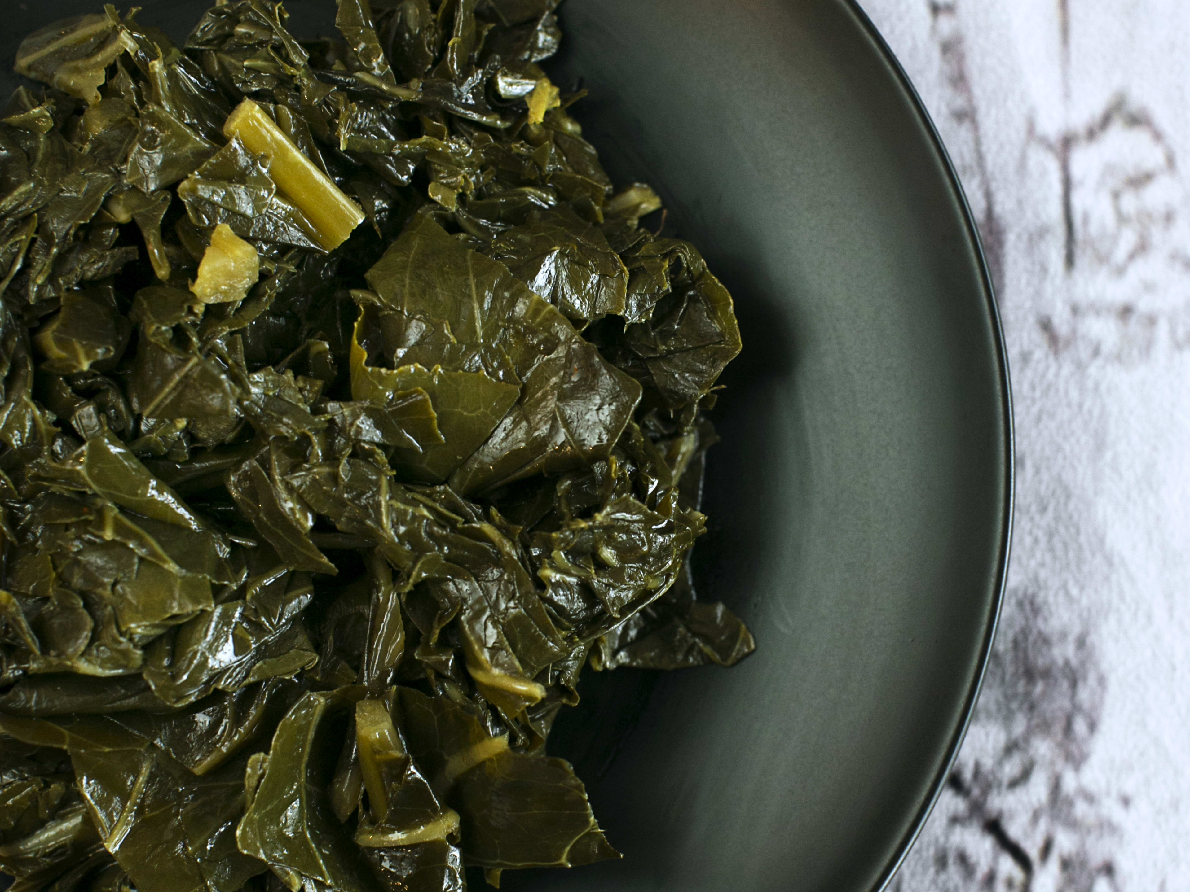 Collard greens on black plate.