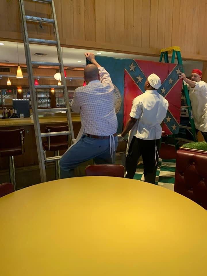 OK Cafe employees removing the controversial Georgia state flag artwork on Friday, June 12, in Atlanta