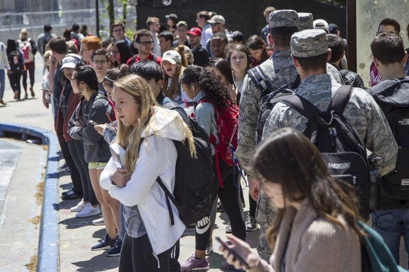 University of Georgia students wait for buses at the Tate Student Center bus stop on the University of Georgia campus in Athens, Georgia, on Tuesday, April 17, 2018. (REANN HUBER/REANN.HUBER@AJC.COM)