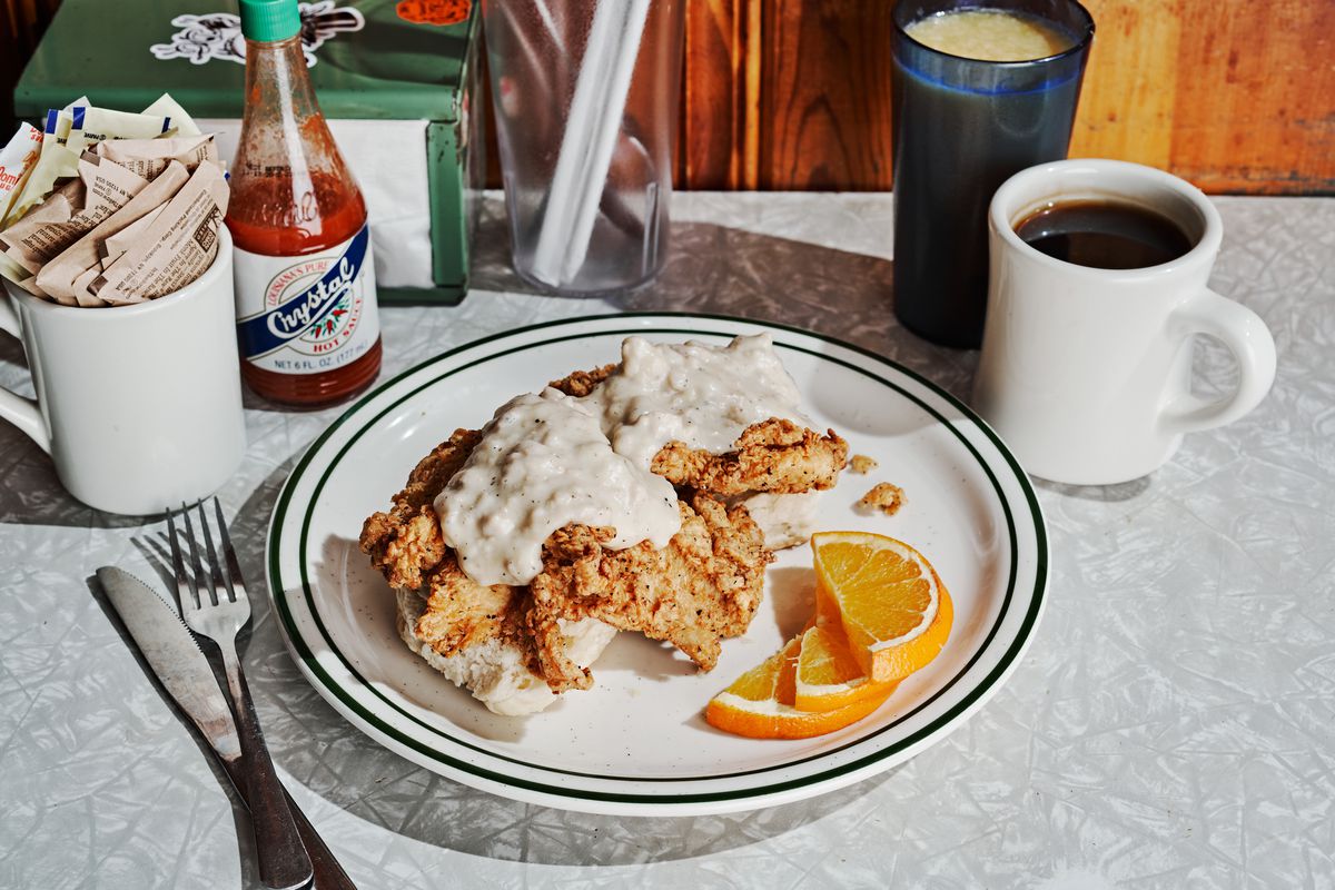 Comfy chicken biscuit covered in sausage gravy and a cup of black coffee at Home Grown in Atlanta, GA.