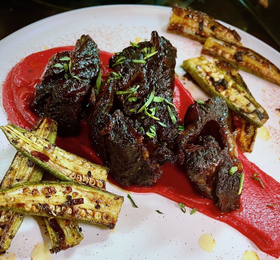 Whiskey and molasses short rib with sliced pan-seared okra, atop a red smoked beet and parsnip puree from Liz and Leon’s in Atlanta.