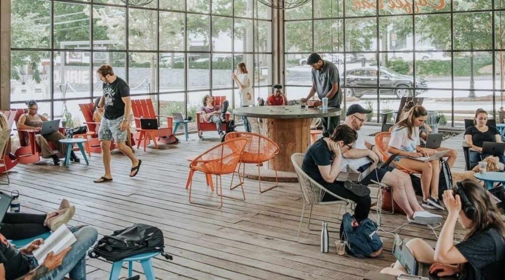 A bright and open space full of people working at tables.