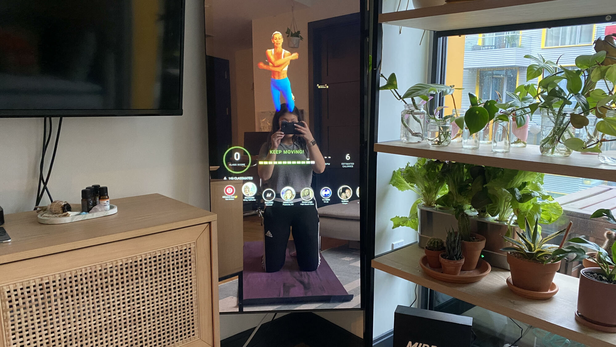 Mirror selfie of person kneeling on a workout mat in front of the Mirror