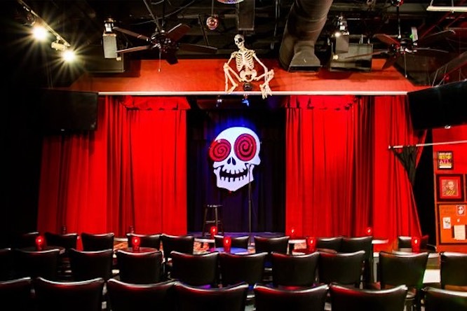 red curtains with a laughing skull image on a stage